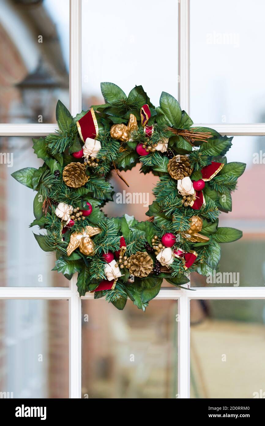 Christmas wreaths, Xmas garland on a wooden glass front door, UK Stock Photo