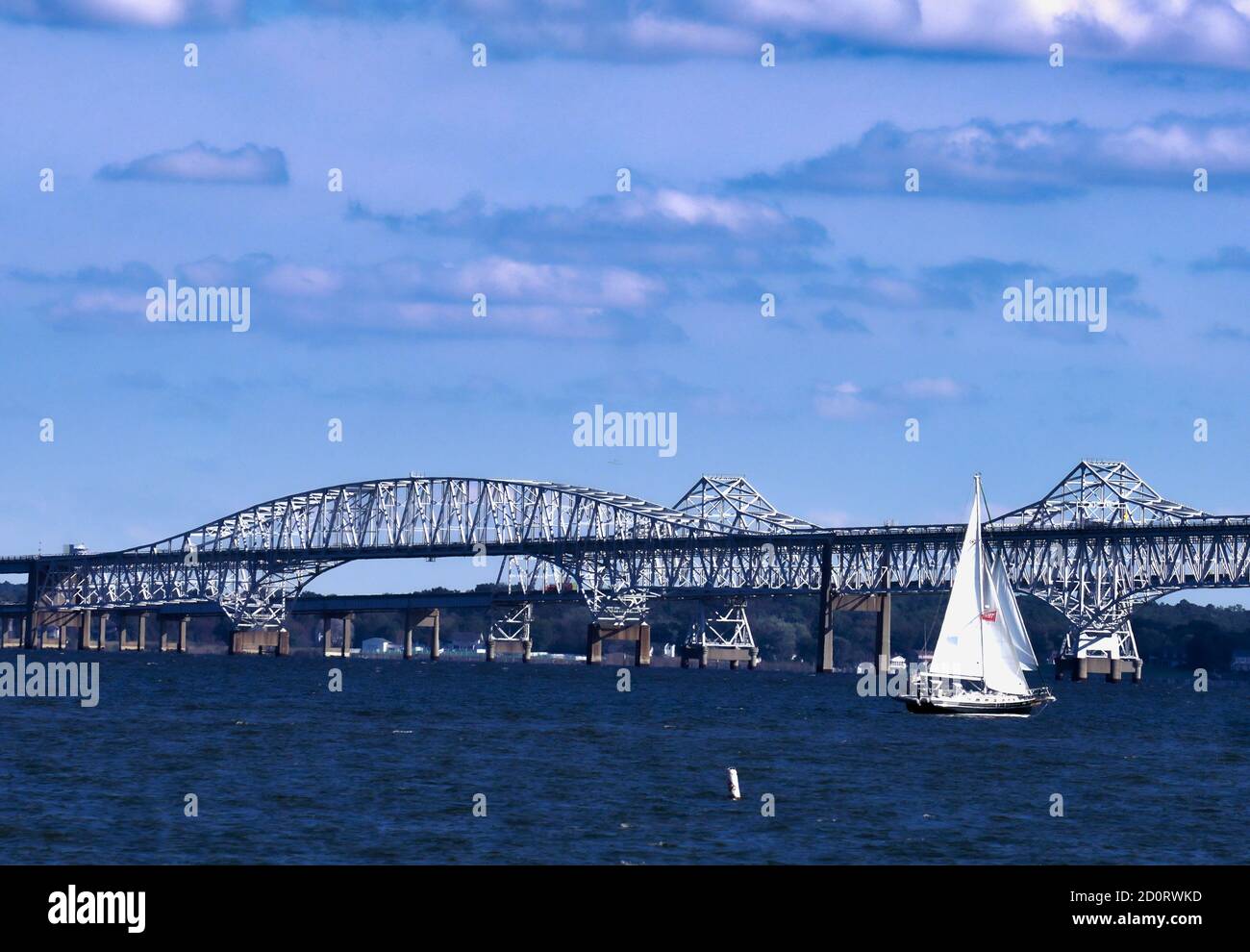 Sailing boat heads towards. the Chesapeake Bay Bridge in Maryland Stock