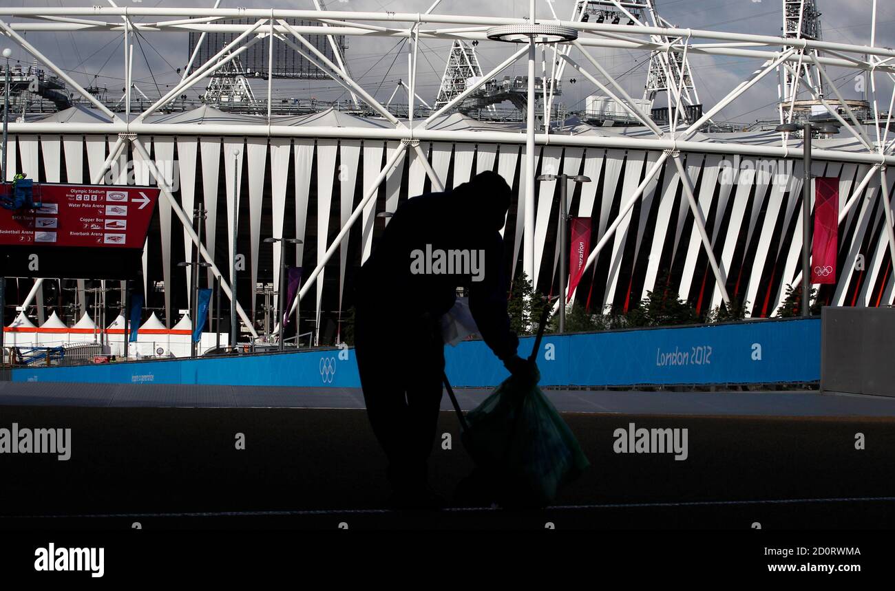 A cleaner sweeps the ground in front of the Olympic Stadium in the Olympic Park, in Stratford, east London, July 19, 2012. The 2012 London Olympic Games will begin in just over a week.  REUTERS/Andrew Winning (BRITAIN - Tags: SPORT OLYMPICS) Stock Photo