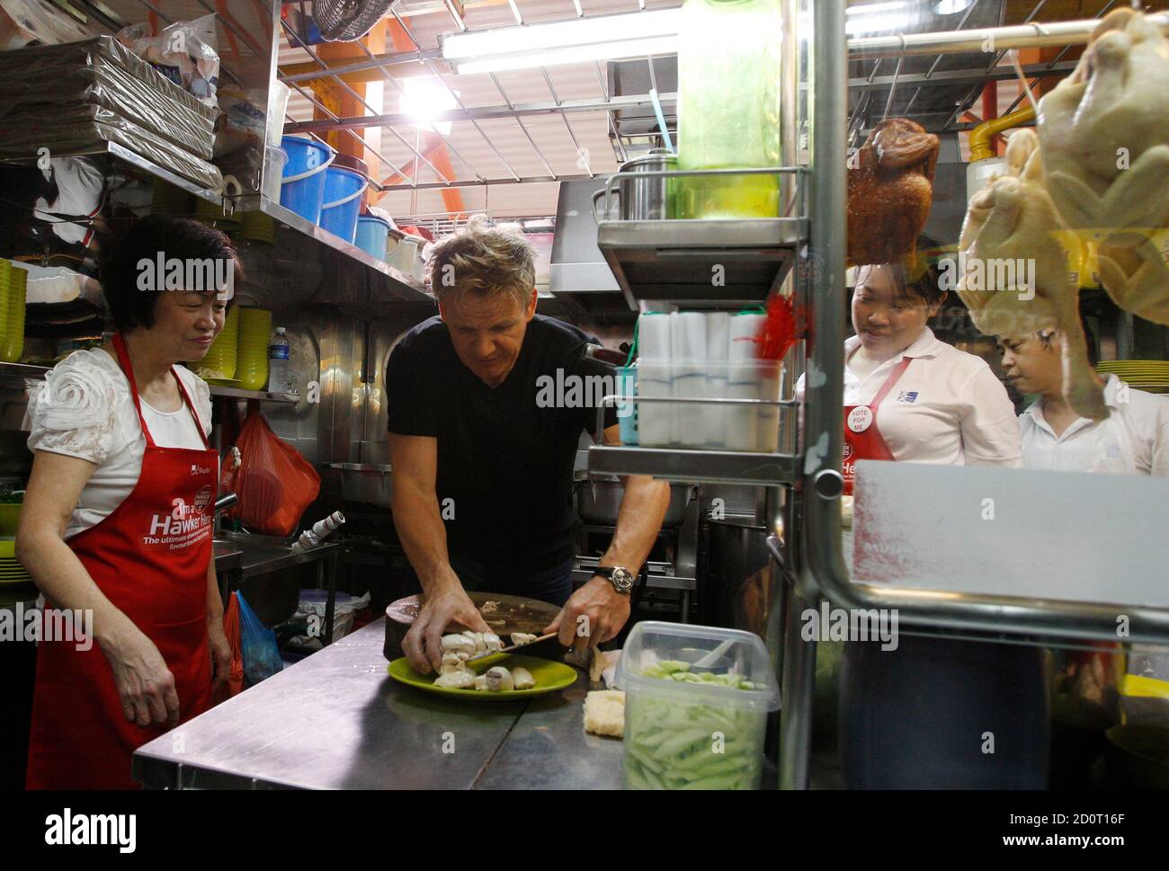 British Celebrity Chef Gordon Ramsay Plates Pieces Of Chicken As He Prepares A Chicken Rice Dish With Madam Foo L Of Tian Tian Hainanese Chicken Rice Stall At A Food Center In