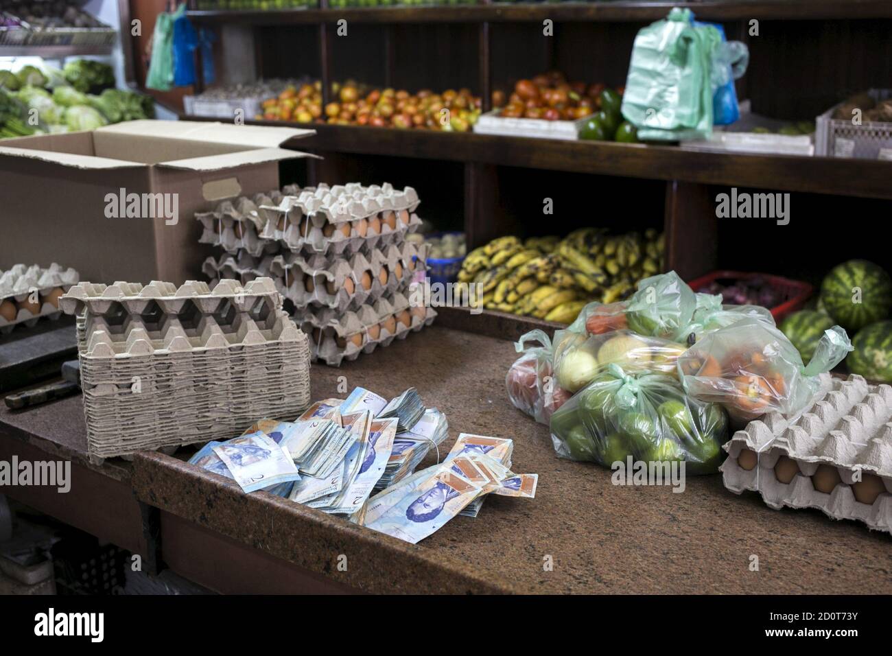 Venezuelan two bolivar banknotes are seen next to some goods at a fruit and vegetable store in Caracas, July 10, 2015. A debilitating recession and a drop in oil prices have harmed the OPEC nation's ability to provide dollars through its complex three-tiered currency control system, pushing up the black market rate at a dizzying speed. The bolivar sank past 600 per U.S. dollar on Thursday, compared with 73 a year ago, according to anti-government website DolarToday. REUTERS/Marco Bello Stock Photo