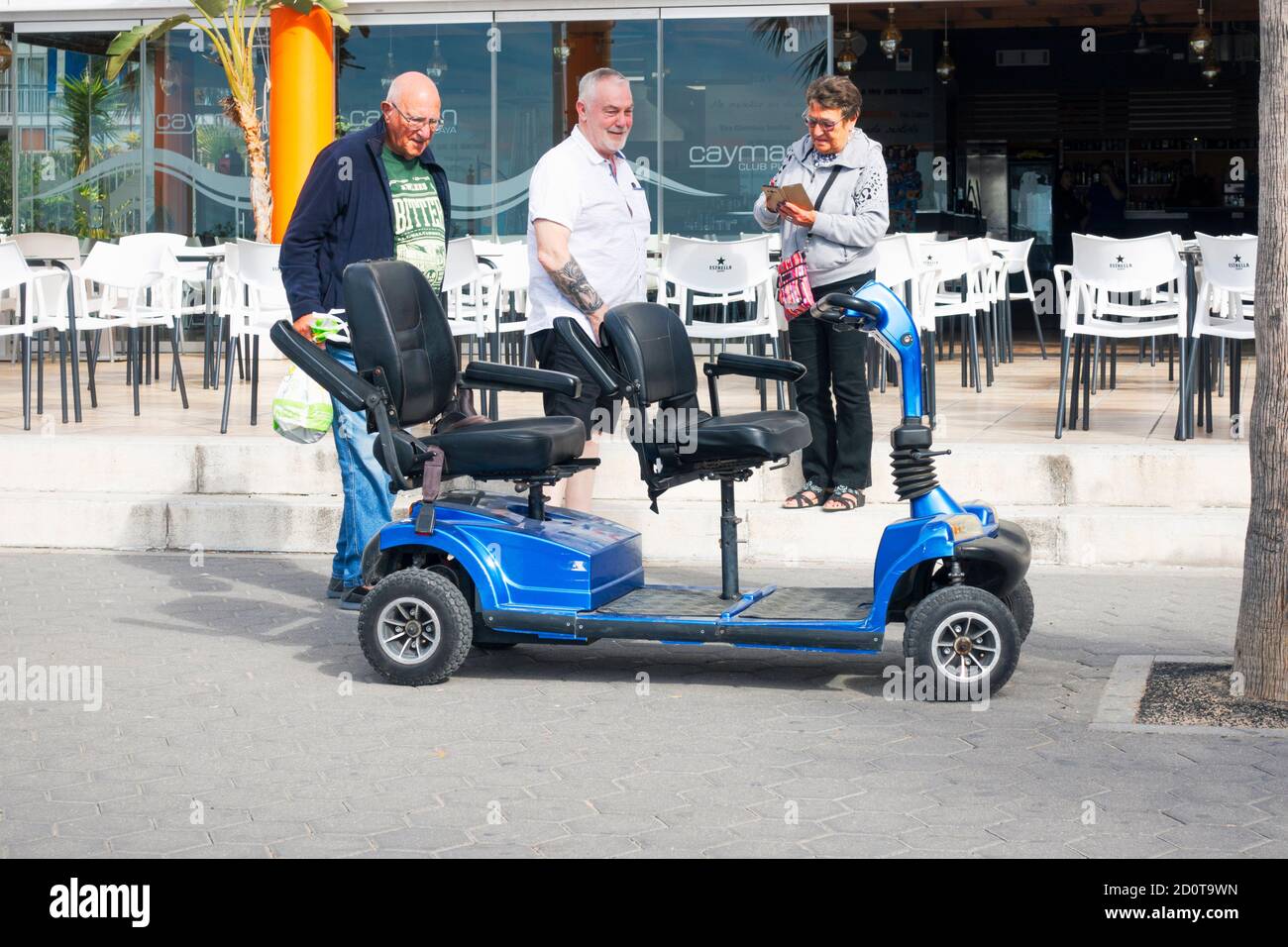 Benidorm, Spain - Holiday makers and disability scooter in Benidorm city  nea outdoors cafe Stock Photo - Alamy