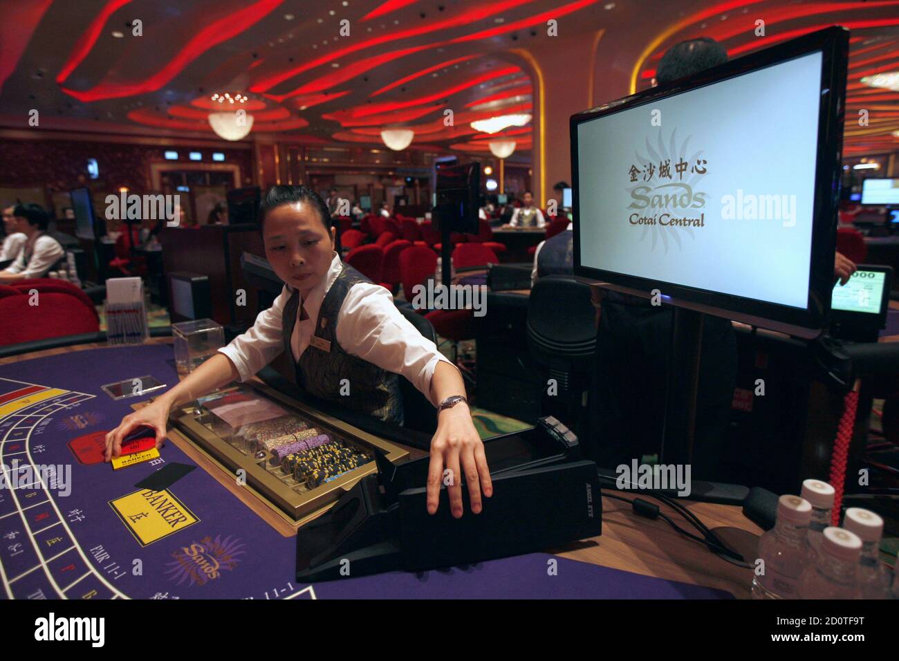 A croupier reacts in front of a gaming table inside a casino on ...