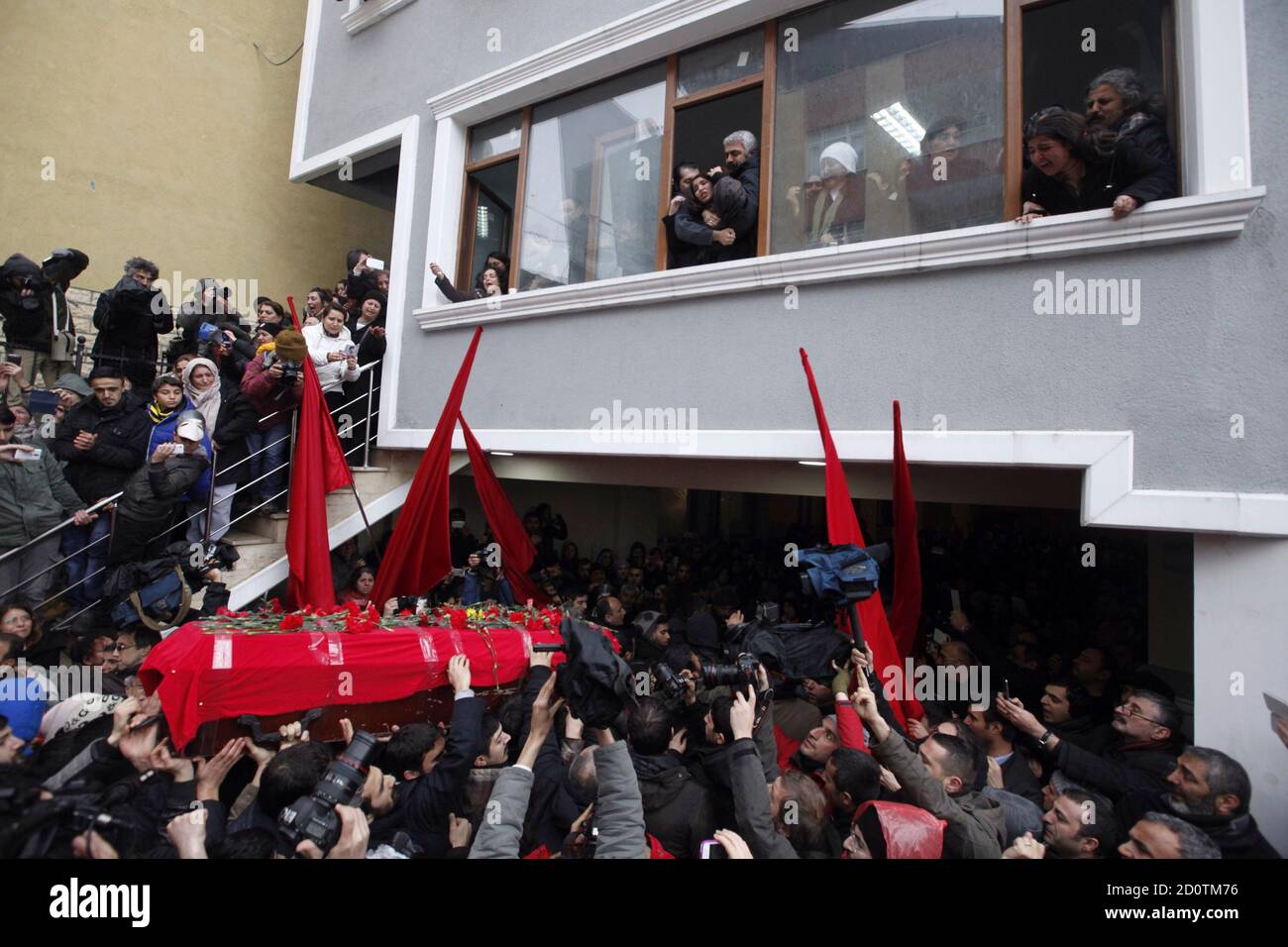 Berkin Elvan's mother Gulsum (R window panel) and sister Ozge (C window panel) react as his coffin arrives at the Okmeydani cemevi, an Alevi place of worship, in Istanbul March 11, 2014. Police and protesters clashed in Turkey's two biggest cities on Tuesday following the death of the 15-year-old boy who suffered a head injury during anti-government demonstrations last summer. Elvan, then aged 14, got caught up in street battles in Istanbul between police and protesters on June 16 after going out to buy bread for his family. He was struck in the head by a tear-gas canister and went into a coma Stock Photo