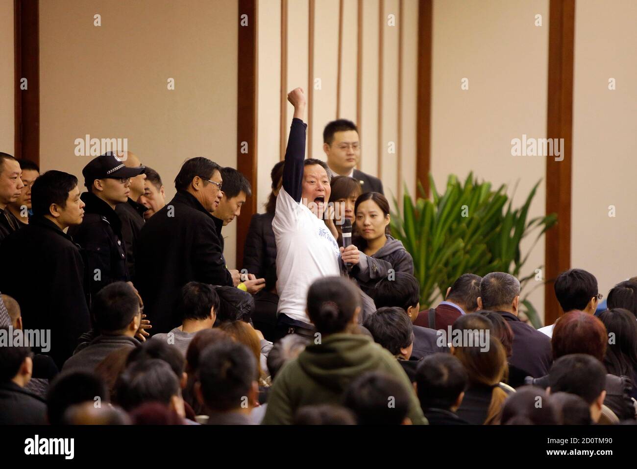 A family member of a passenger onboard Malaysia Airlines Flight MH370 raises his fist as he shouts slogans to protest against the lack of new information after a routine briefing given by Malaysia Airlines at Lido Hotel in Beijing, March 22, 2014. Two weeks after a Malaysia Airlines airliner went missing with 239 people on board, officials are bracing for the 'long haul' as searches by more than two dozen countries turn up little but frustration and fresh questions. REUTERS/Jason Lee (CHINA - Tags: DISASTER TRANSPORT) Stock Photo