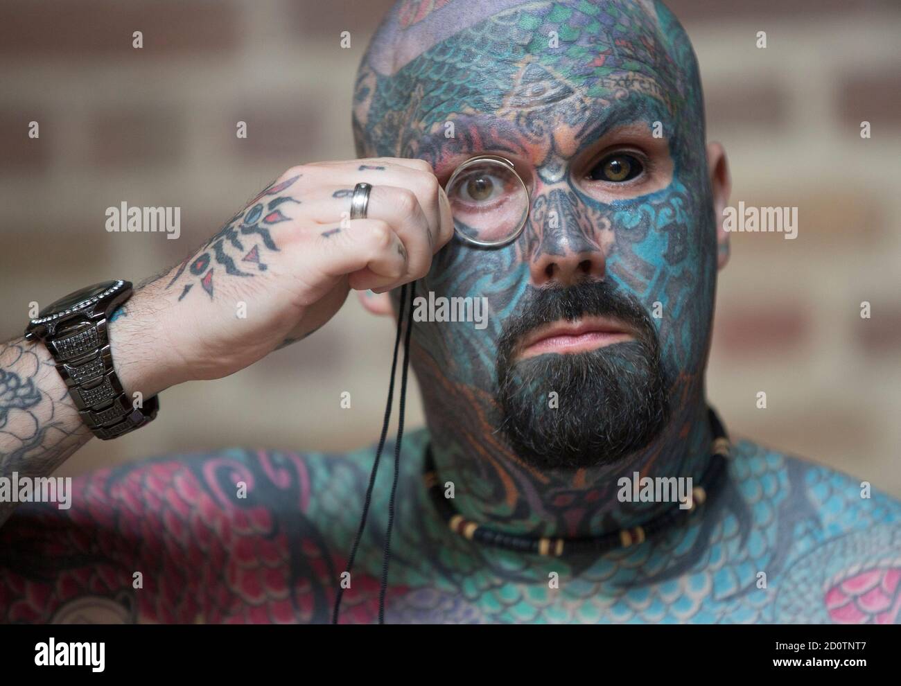 A man who has changed his name to King of Ink Land King Body Art The  Extreme Ink-ite adjusts his monocle as he poses during the 10th  International Tattoo Convention in London
