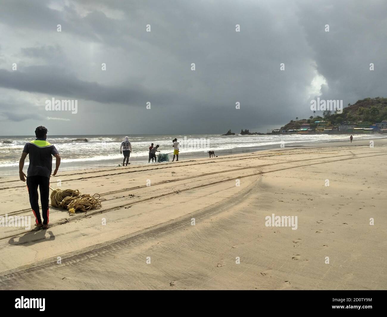 Arambol Beach, Goa, India - June 6, 2020: Fishermen gathering their fishing nets during the monsoon season Stock Photo