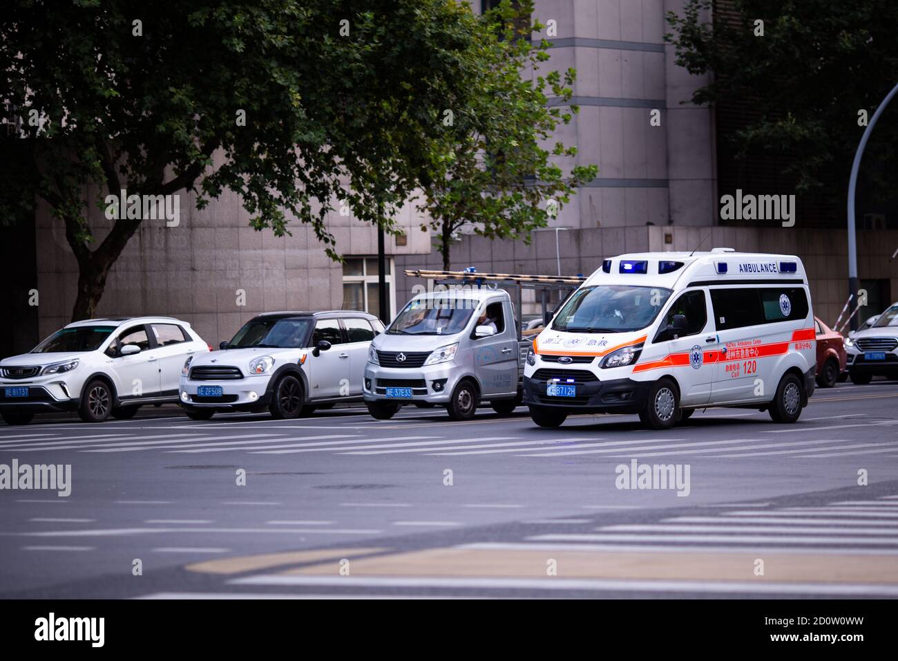 Huzhou, China 2020 September 28: Ambulance Car rush hours city street. Cars on road in traffic jam on pedestrian Stock Photo