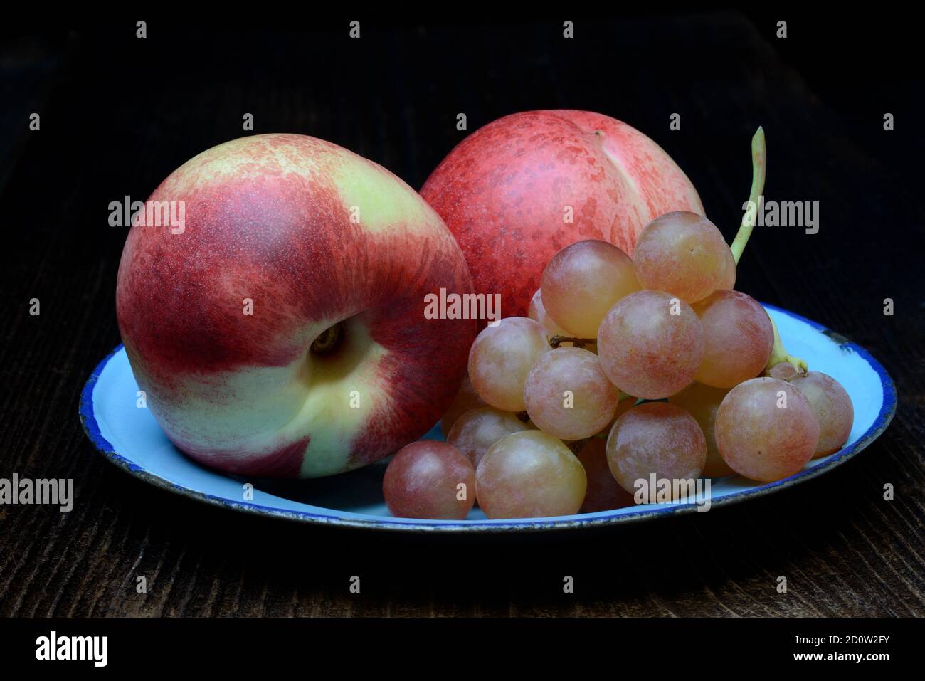 Nectarines and table grapes on plate, Germany, Europe Stock Photo