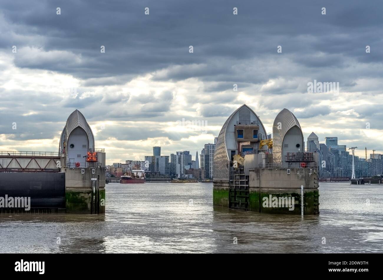 Thames Barrier on the River Thames against the Canary Wharf skyline, London Stock Photo