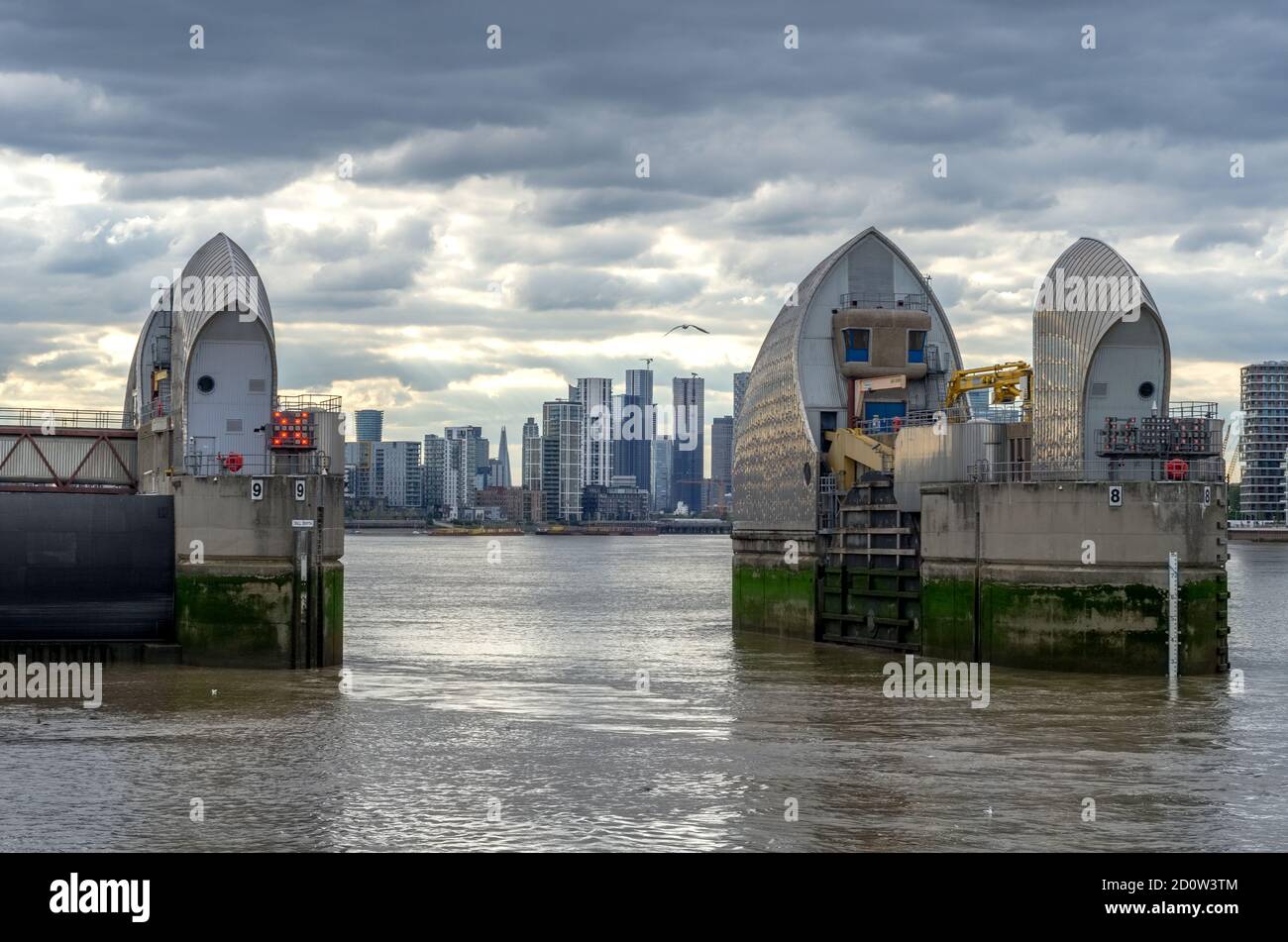 Thames Barrier on the River Thames against the Canary Wharf skyline, London Stock Photo