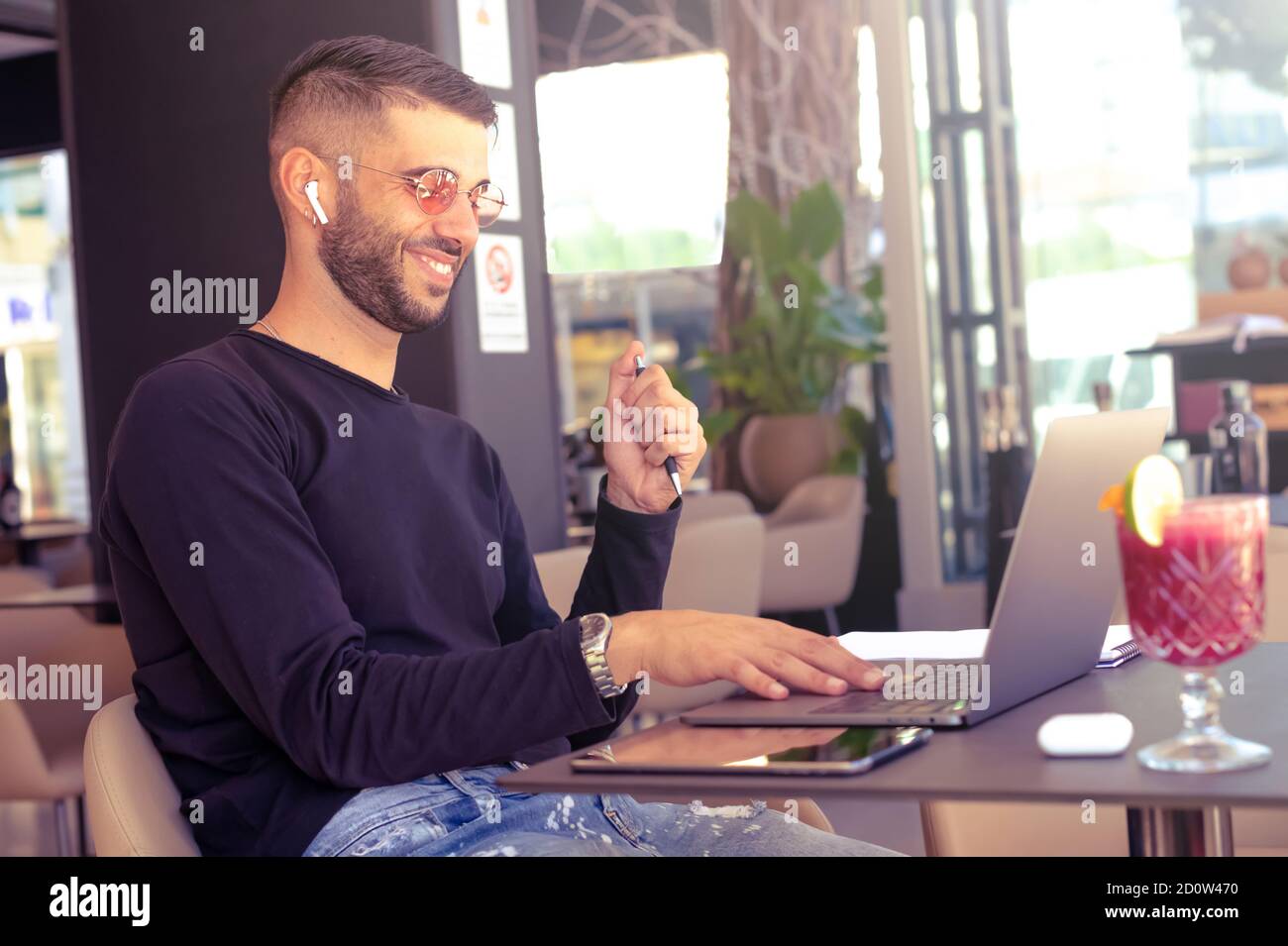 Happy businessman talking with family via laptop computer in cafe - Student learning or entrepreneur working with a laptop in a bar terrace - Busy peo Stock Photo