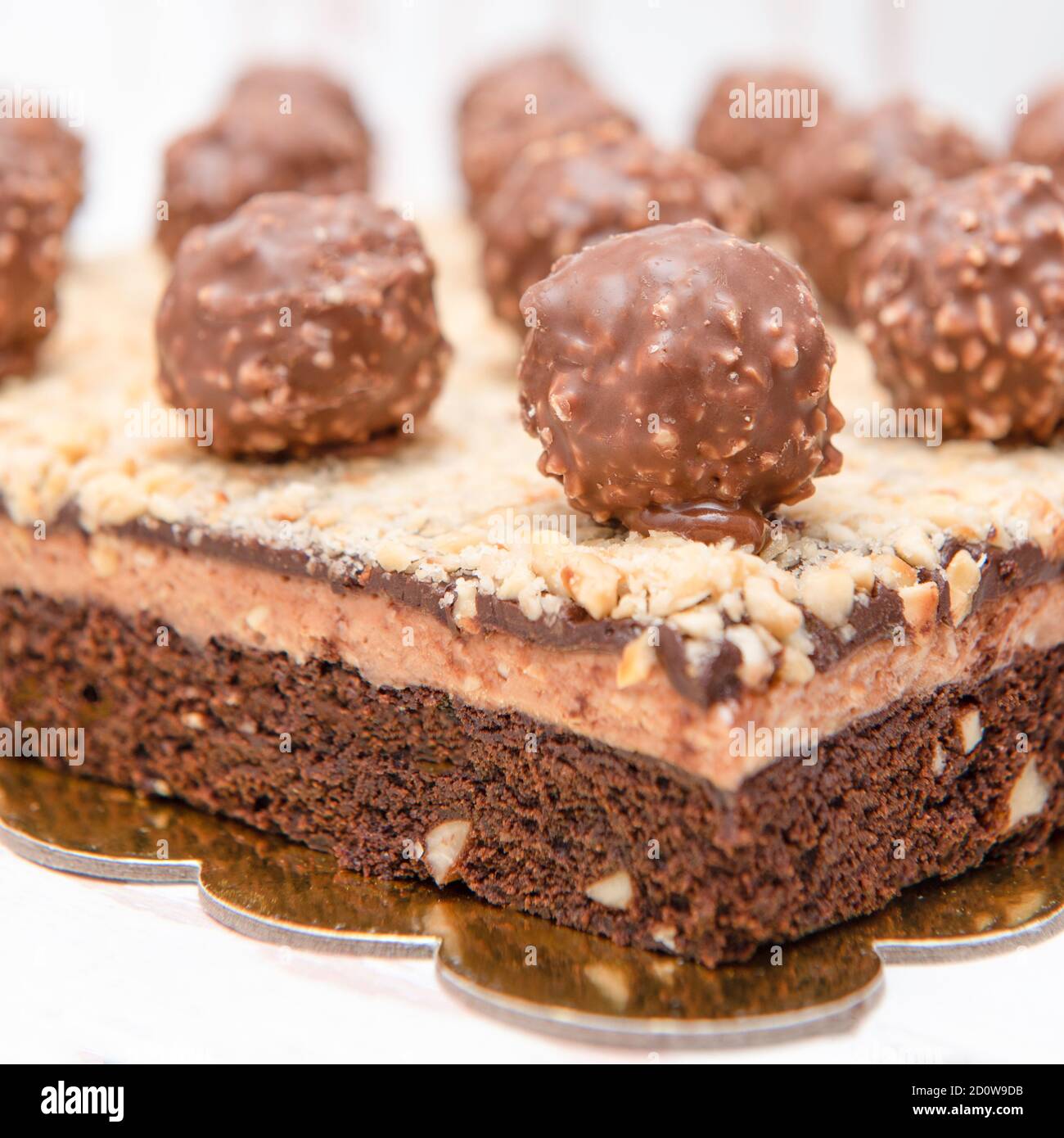 Brownie dessert with ferrero rocher balls and layer of chopped walnuts Stock Photo