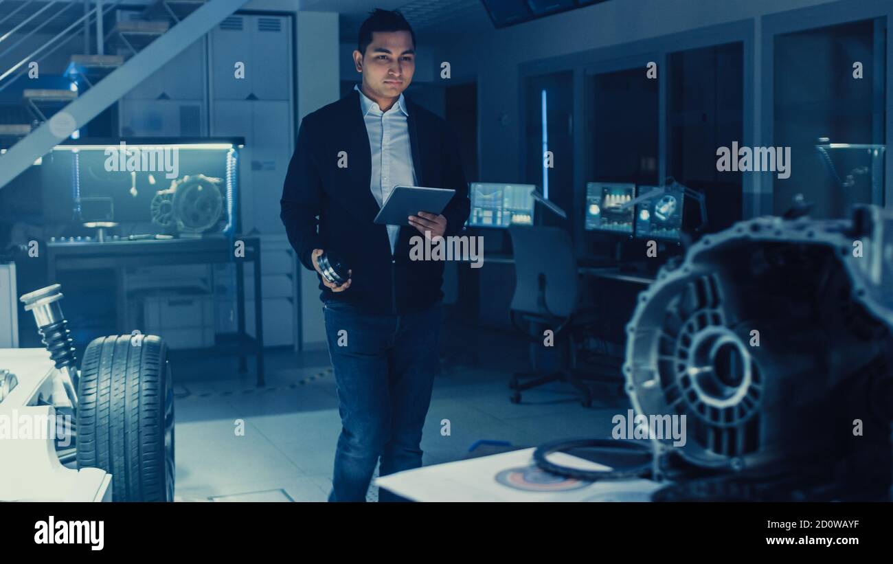 Development Laboratory Room with Professional Automotive Design Engineer Working on a Electric Car Chassis with Wheels, Batteries, Engine and Stock Photo