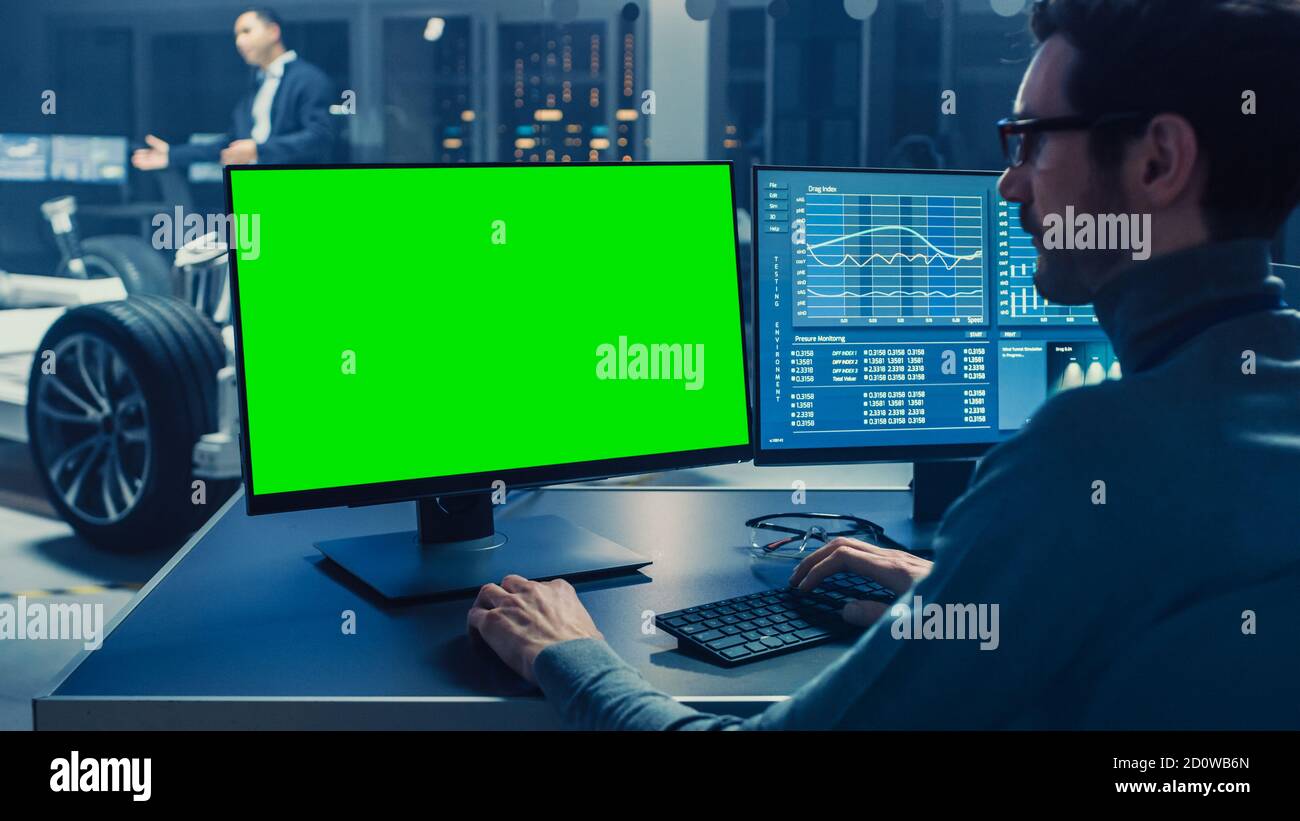 Professional Engineer Works on a Computer with Green Screen Mock Up and