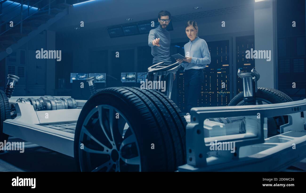 Automobile Mae and Female Design Engineers Working on Electric Car Platform Chassis Prototype, Using CAD Software for 3D Concept. In Automotive Stock Photo