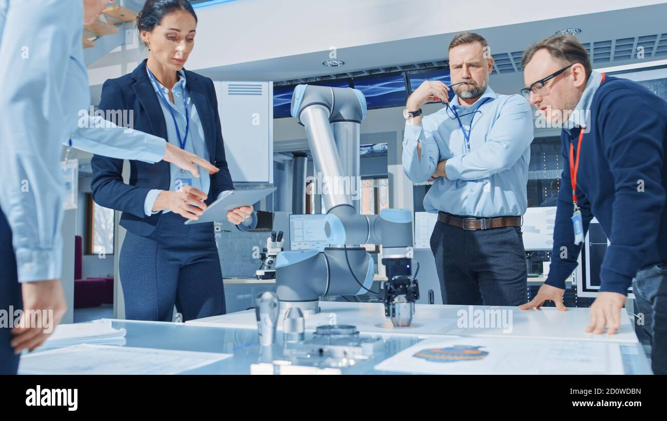 Diverse Team of Industrial Robotics Engineers Gathered Around Table