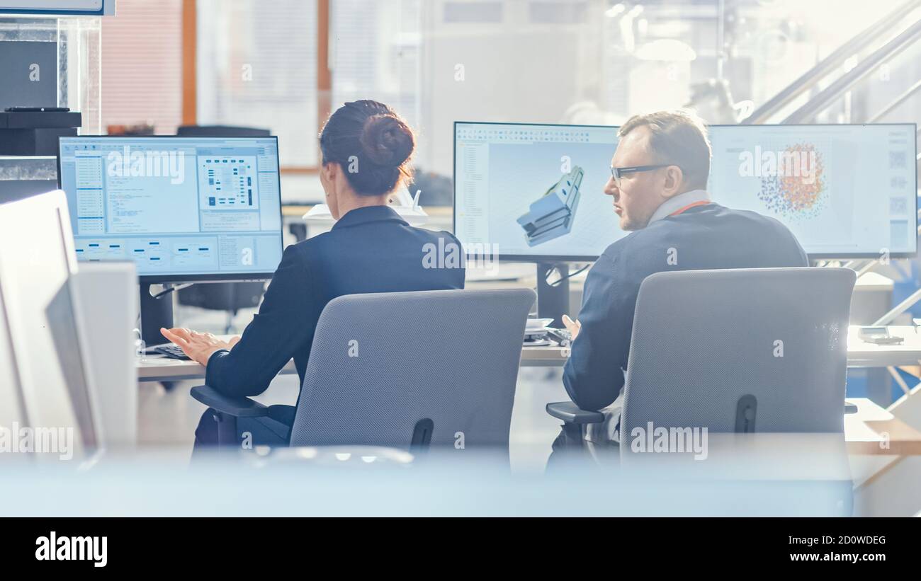 Back View of Team of Technology Engineers Working on Desktop Computers