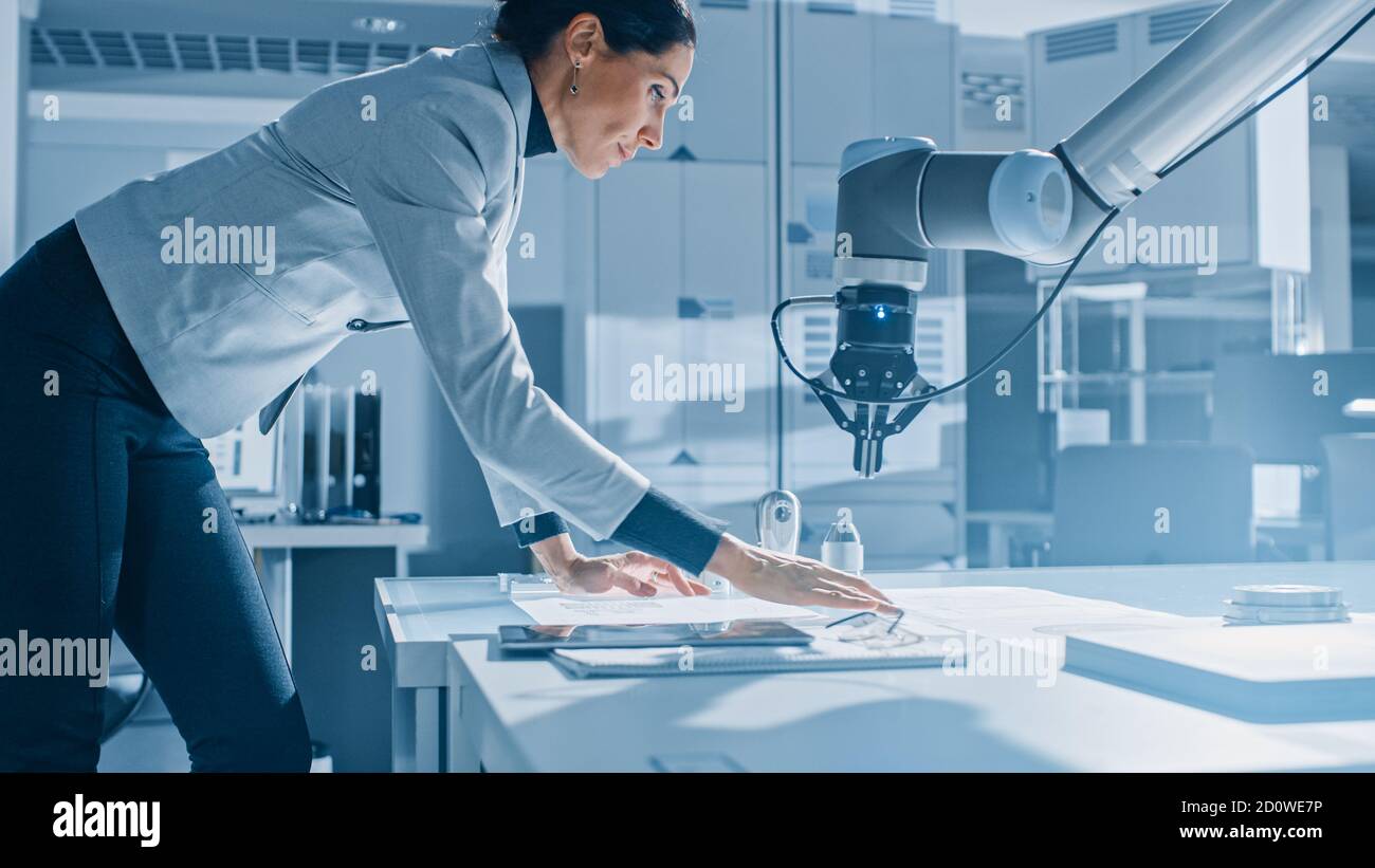 Stylish Female Robotics Engineer Leans on the Table Works with