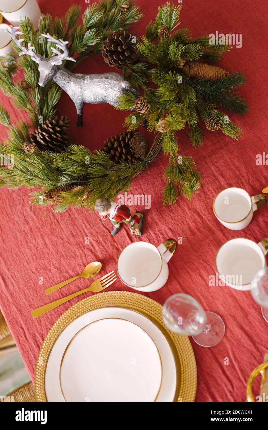 White plates with gold rims, champagne glasses, a fir wreath in the serving of a festive dinner for Christmas, Christmas eve. Top view Stock Photo