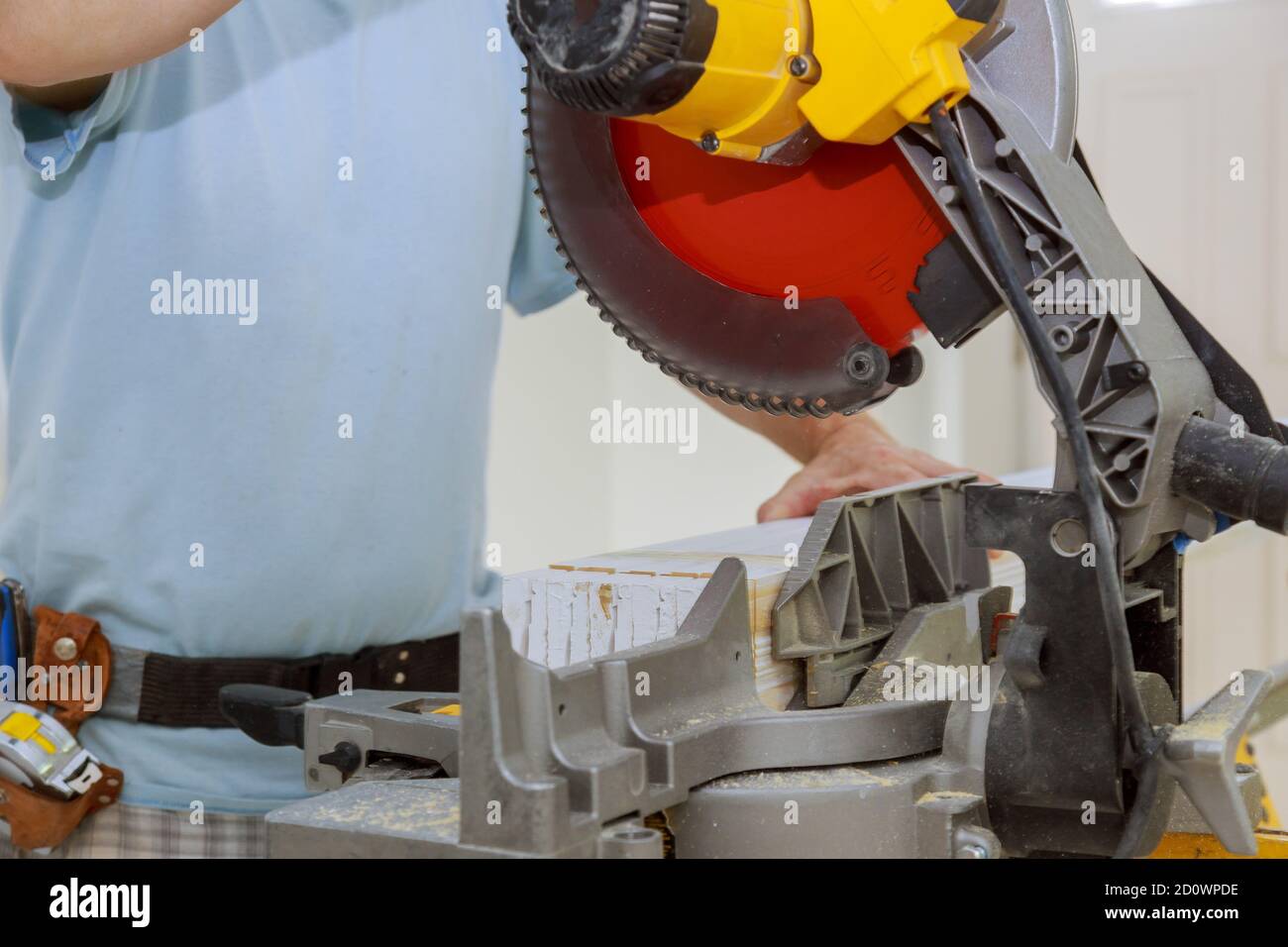 Circular saw cutting new baseboard for new home construction interior finish details Stock Photo