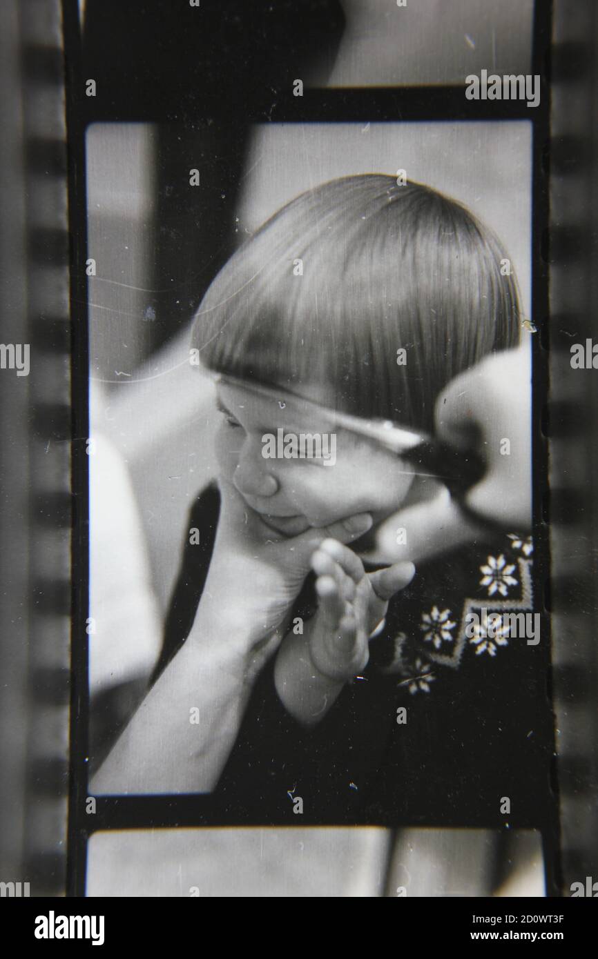 Fine 1970s vintage black and white photography of a young girl getting a pageboy haircut by her mother. Stock Photo