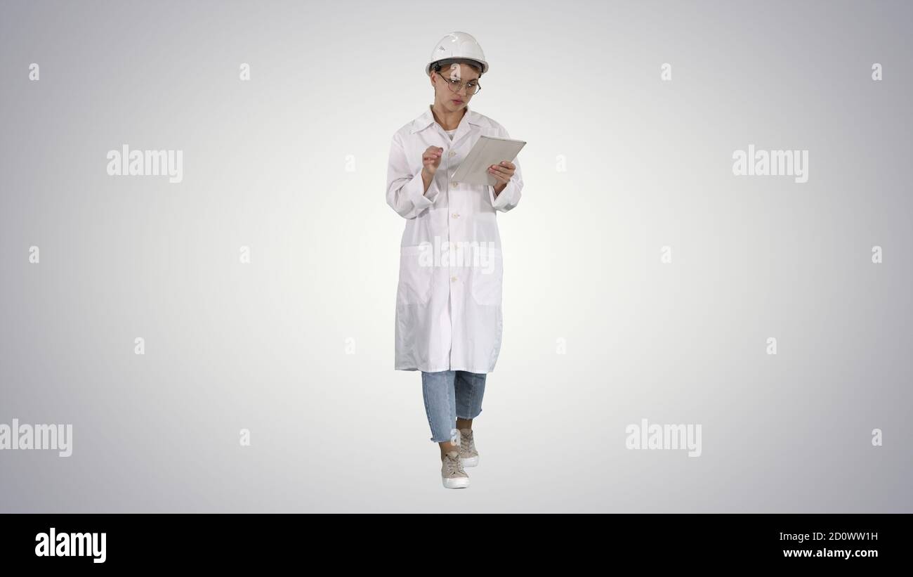 Woman engineer working on tablet on gradient background. Stock Photo