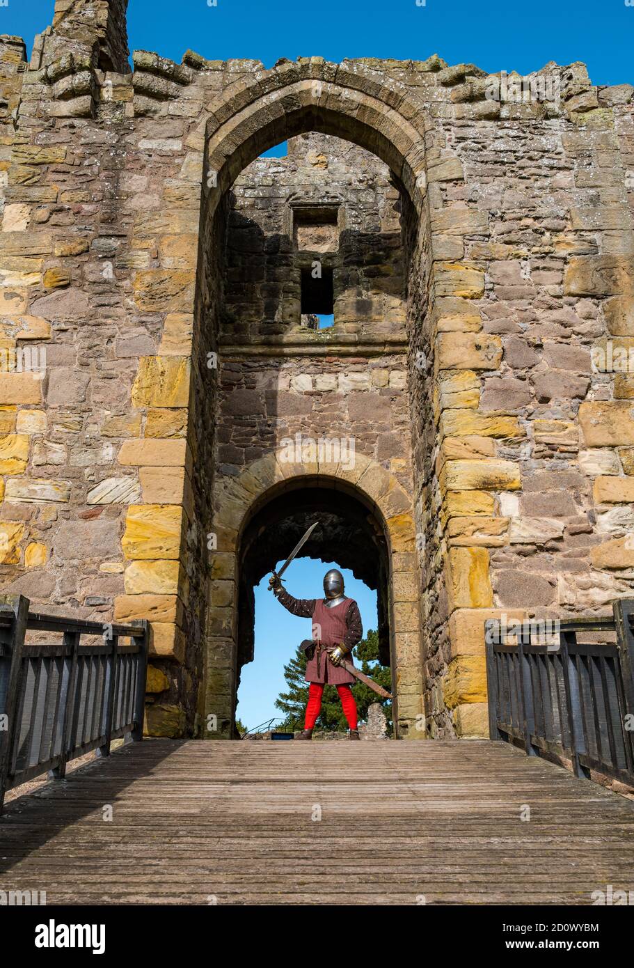 Knight with sword at entrance to ruined Dirleton Castle over moat, East Lothian, Scotland, UK Stock Photo