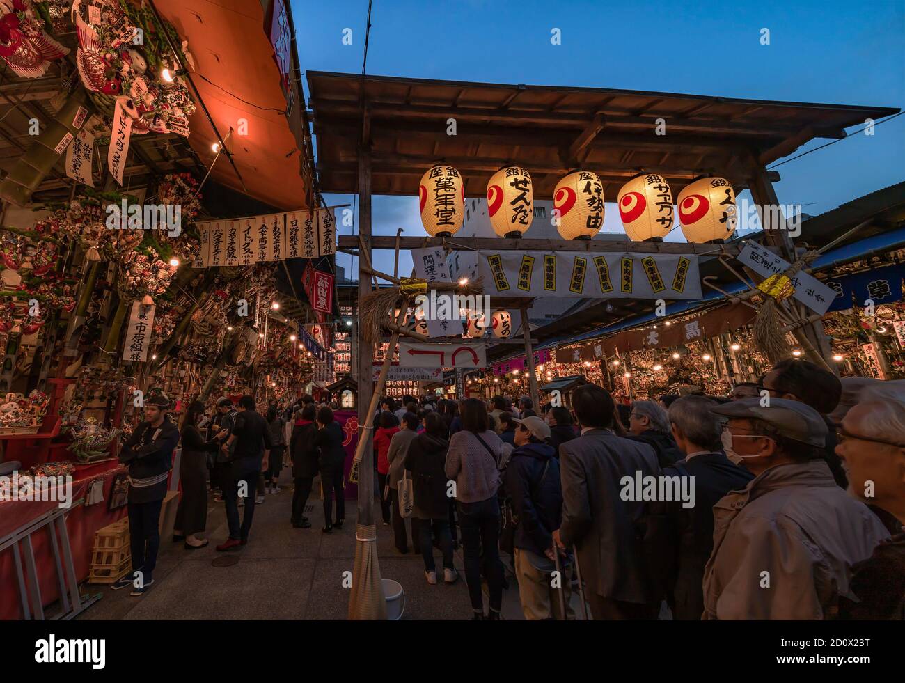 asakusa, japan - november 08 2019: Crowds agglutinated at the  gate of the Ootori shrine decorated with paper lanterns to buy auspicious bamboo rakes Stock Photo