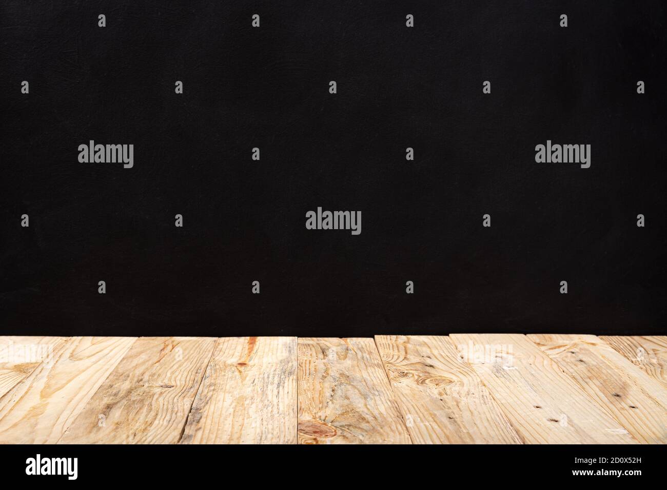 Empty wooden deck table over black wall background. Mock up template. Copy space Stock Photo