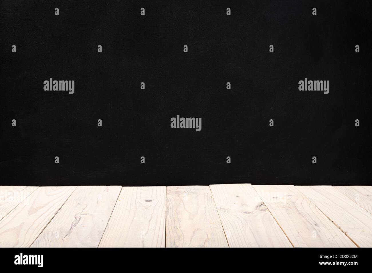 Empty white wooden deck table over black wall background. Mock up template. Copy space Stock Photo