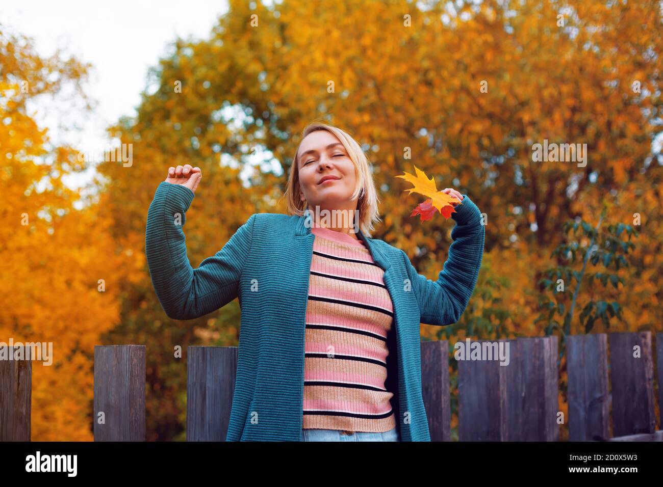 Happy blonde caucasian woman stretching with pleasure. Female with closed eyes Stock Photo