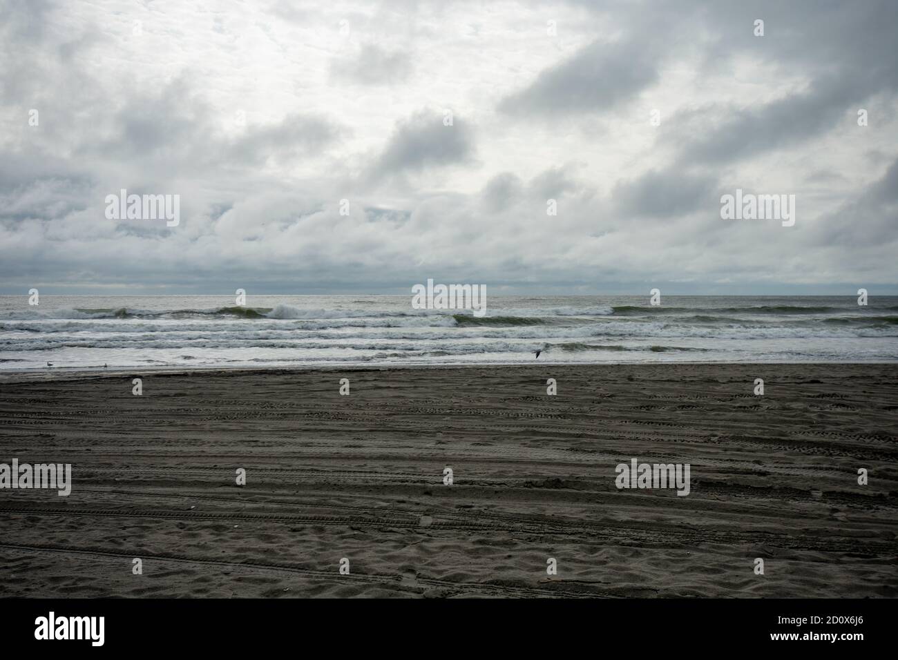 A Dramatic Stormy and Cloudy Sky Over a Dark Colored Beach Stock Photo ...