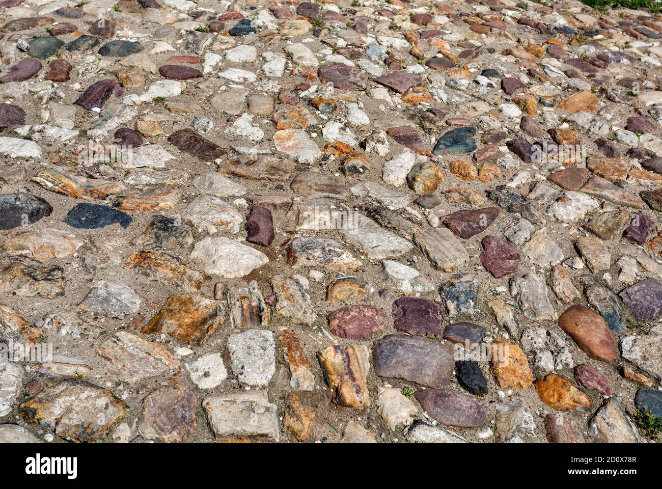 Old cobblestone pavement on the road as creative background texture Stock Photo