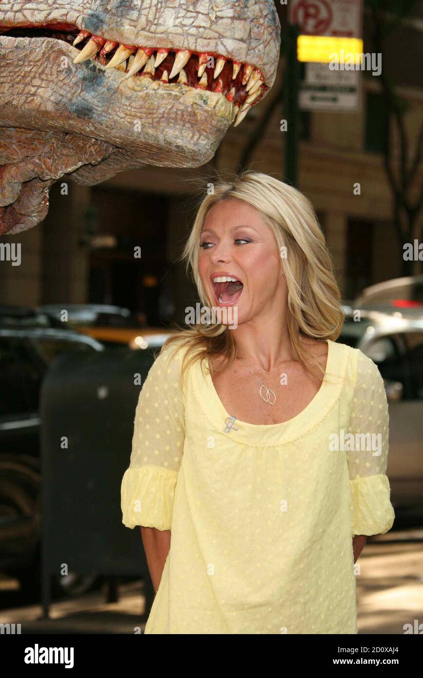 Kelly Ripa filming a segment with a life-sized dinosaur from "Walking