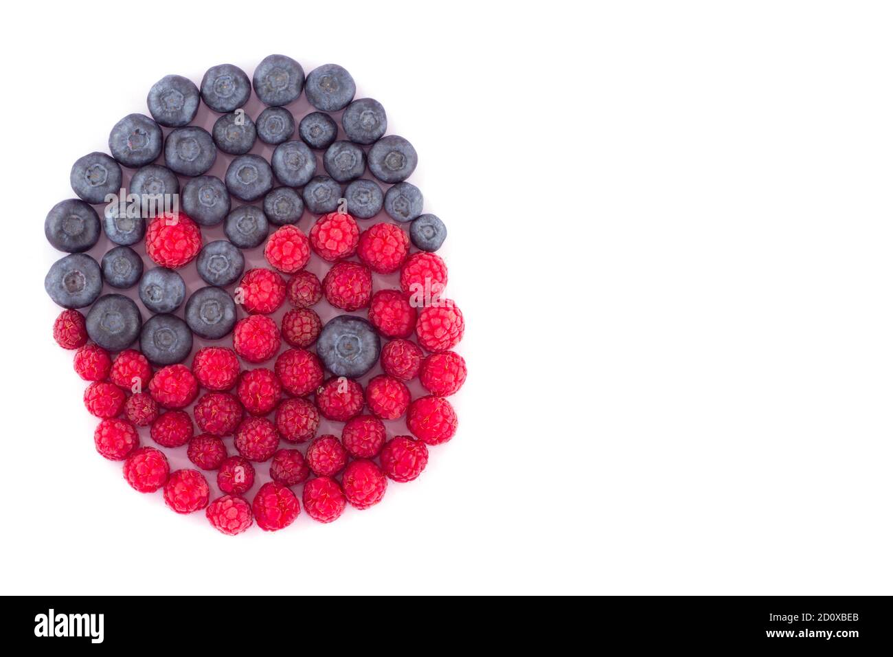 A group of blueberries and raspberries spread out as a Yin-Yang symbol on a white background. Can serve as an illustration of the topic of healthy eat Stock Photo