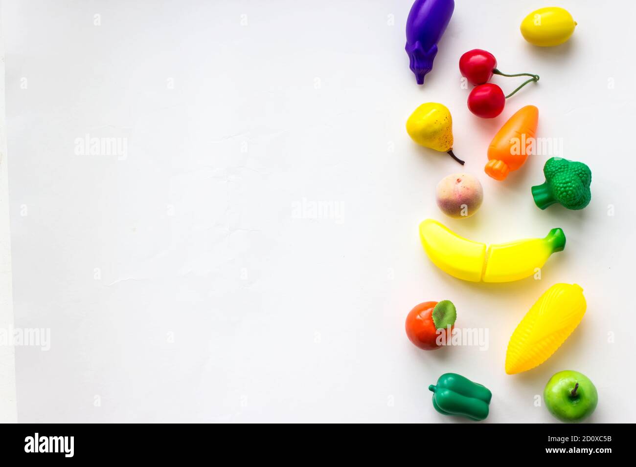 Mini toy vegetables and fruits on white background. Concept of healthy