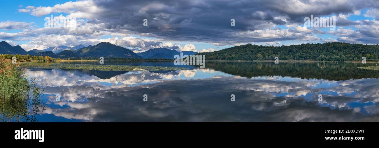 Mountains reflected in lake water in Autumn, Lago di Alserio, Lombardy, Italy Stock Photo