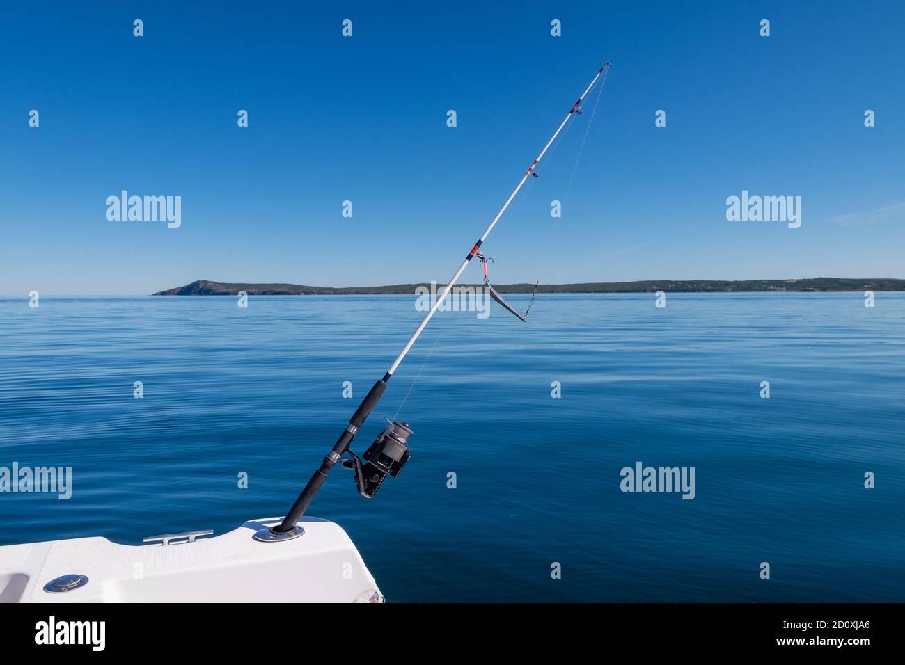 Clear beautiful calm ocean with a landmass in the background. The sky is bright blue. Stock Photo