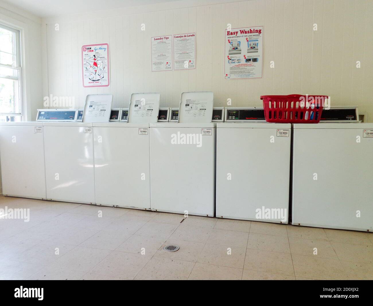 Washing machines and laundry basket in an apartment laundry room. Stock Photo
