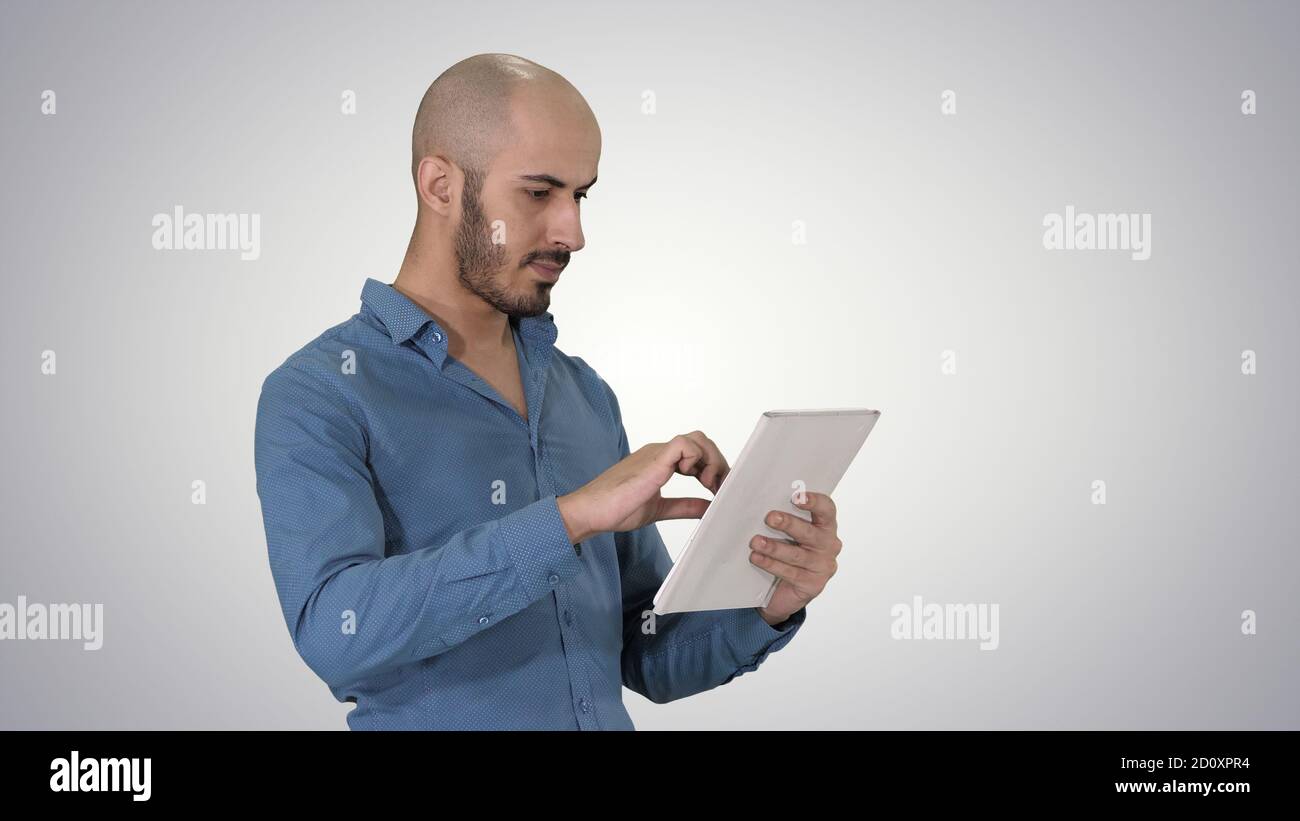 Handsome arabic business man using tablet on gradient background Stock Photo