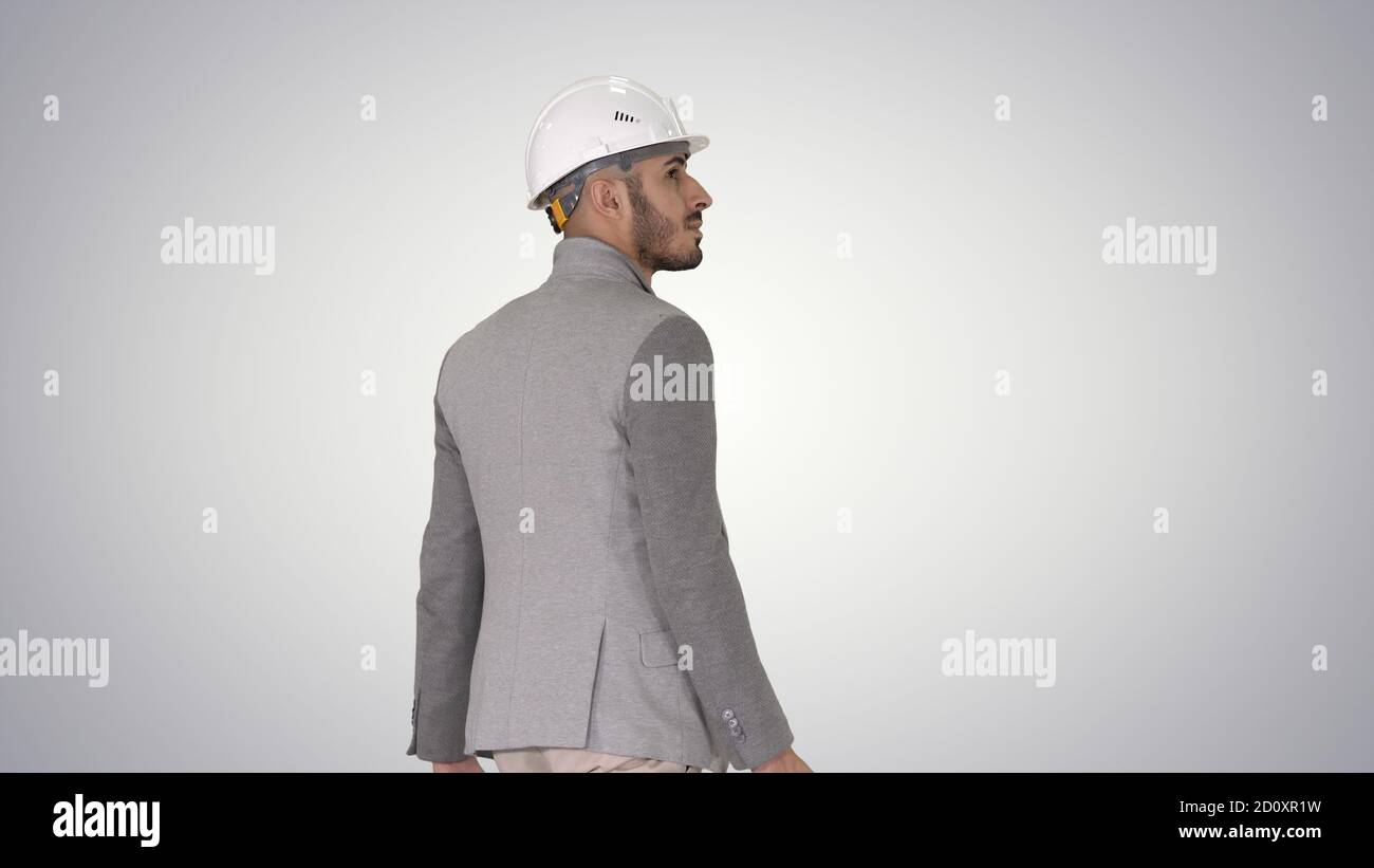 Engineer in helmet with briefcase walking on gradient background Stock Photo