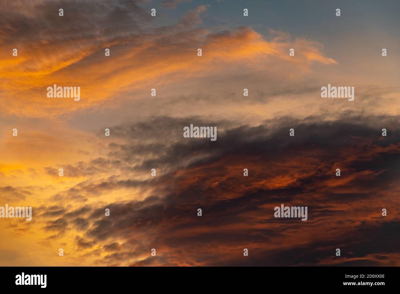 warm coloured contrasting clouds during a morning sunrise background Stock Photo