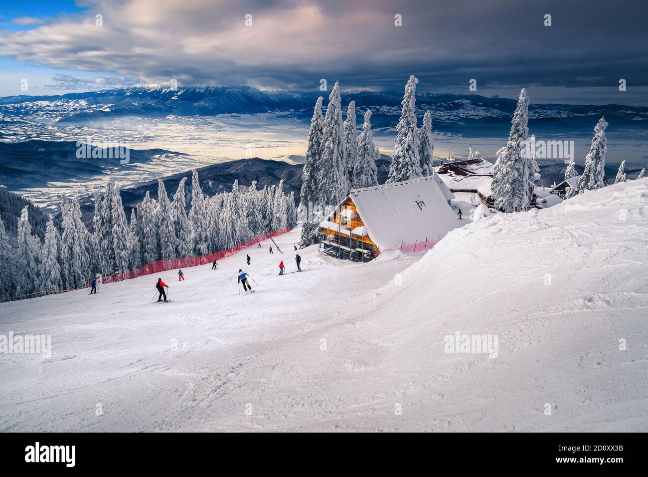 Amazing winter recreation places and ski slopes with snow covered trees. Active skiers on the slopes in Poiana Brasov ski resort, Transylvania, Romani Stock Photo