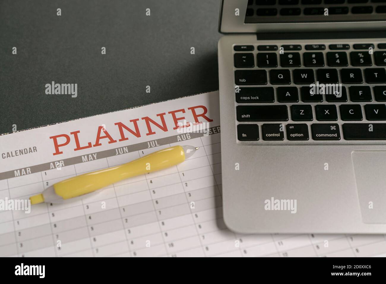 Calendar planner with computer laptop on table. Planning and organizing activities concept. Stock Photo