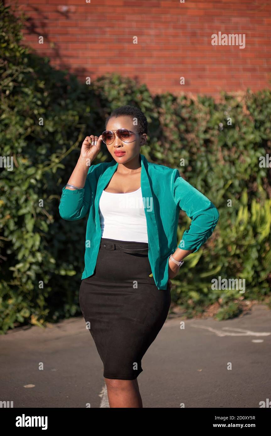 corporate black woman in natural enviroment with heels and sun glasses Stock Photo