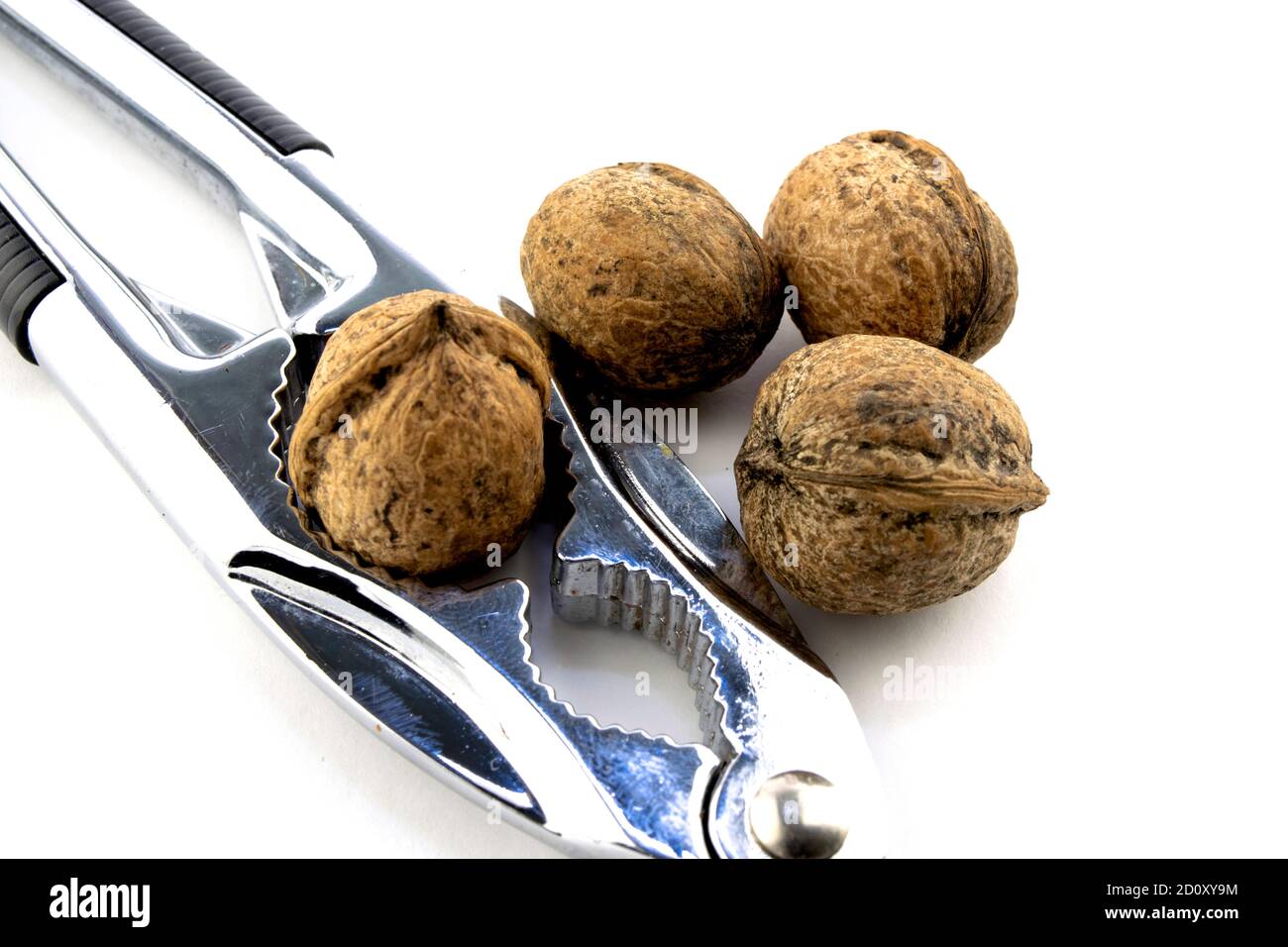 whole walnuts and nutcracker on white background close-up Stock Photo