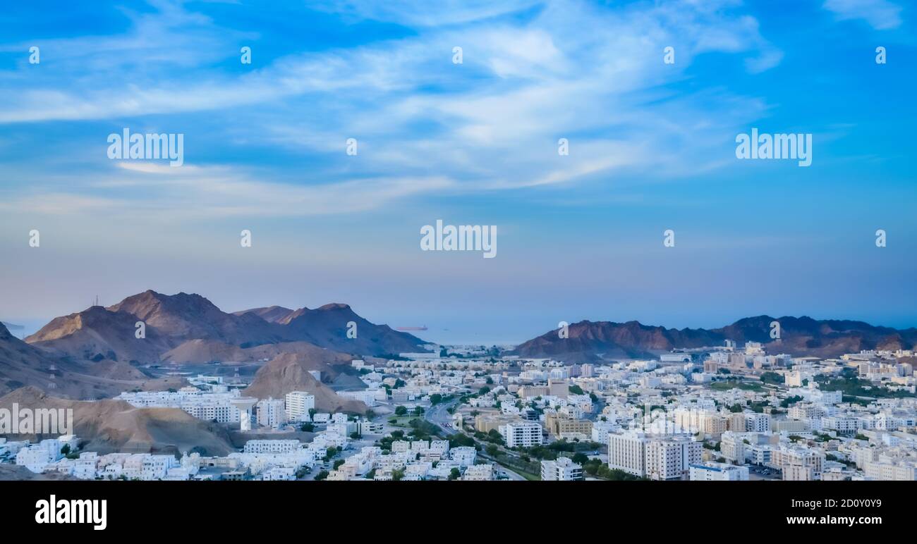 Wide View of Muscat Cityscape with blue sky and mountains from the top of a hill. From Oman. Stock Photo