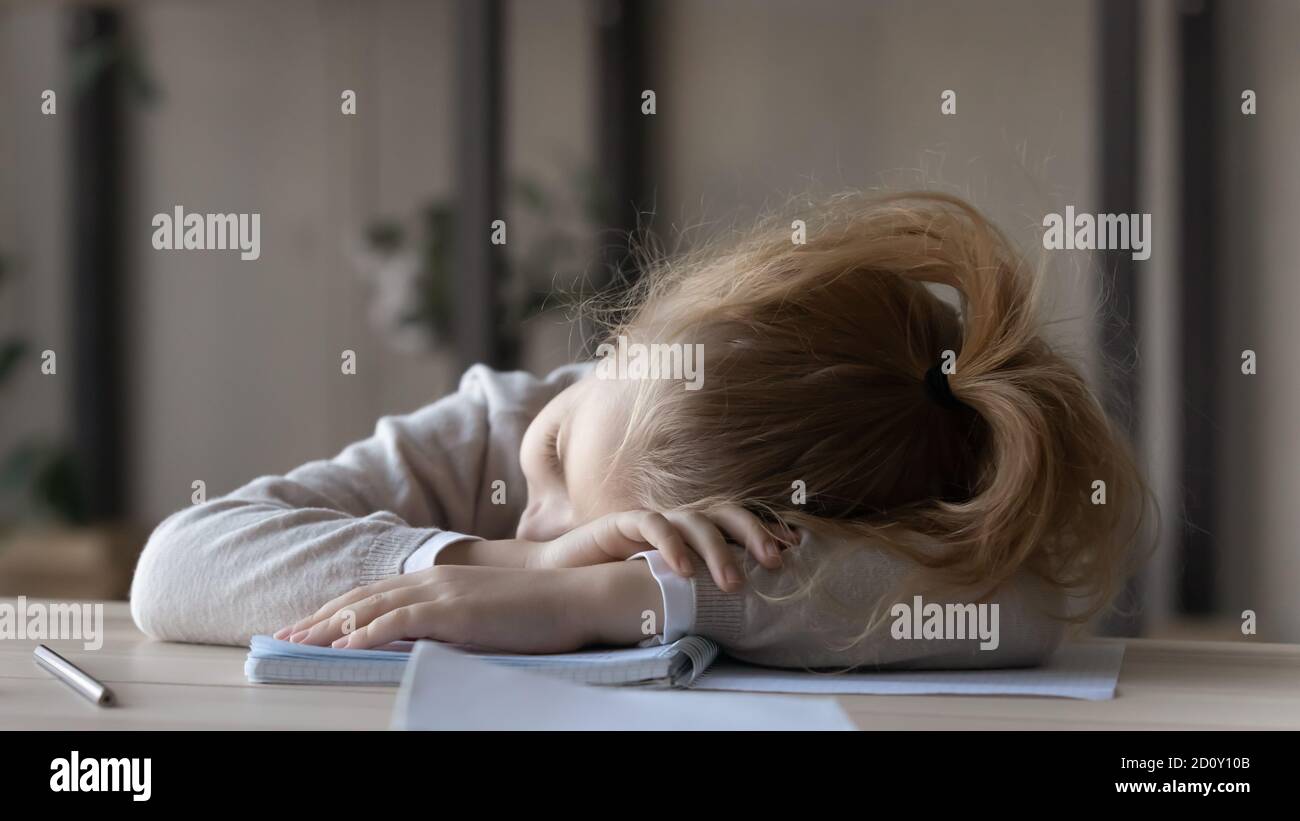 Close up tired little girl sleeping at work desk Stock Photo - Alamy