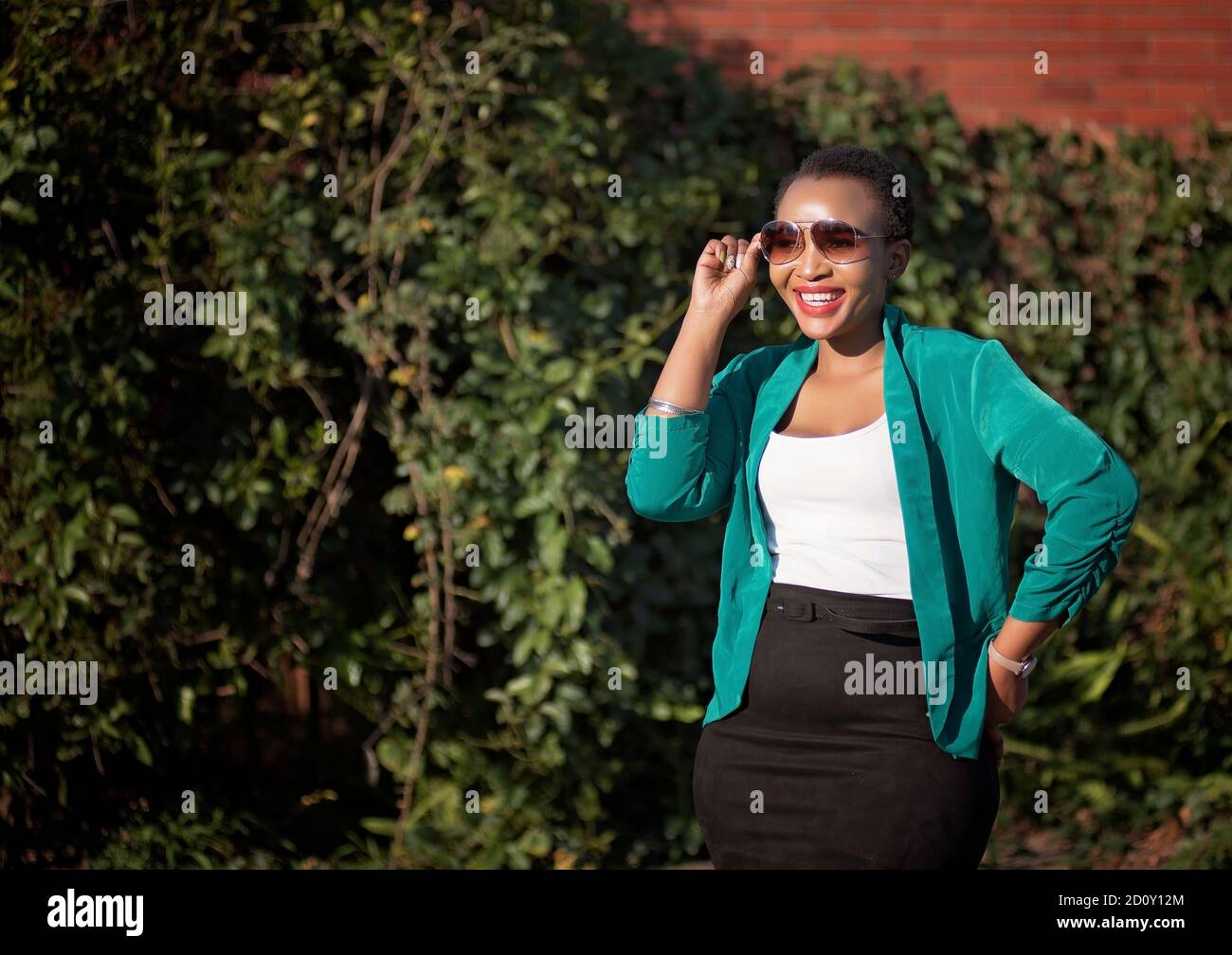 corporate black woman in natural enviroment with heels and sun glasses Stock Photo